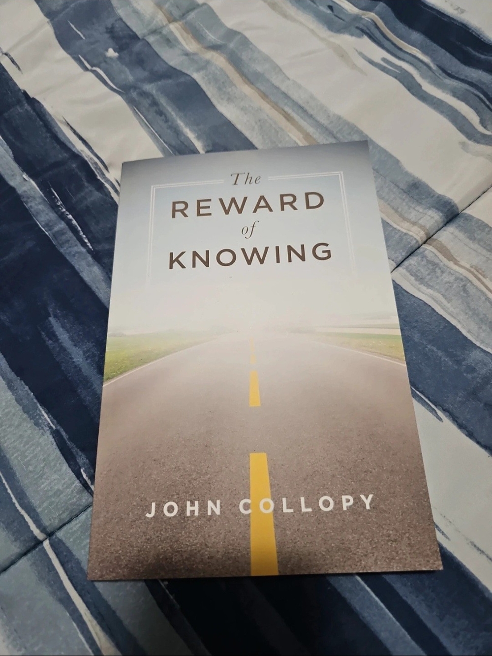 The Reward of Knowing by John Collopy - White/Gray Book Cover